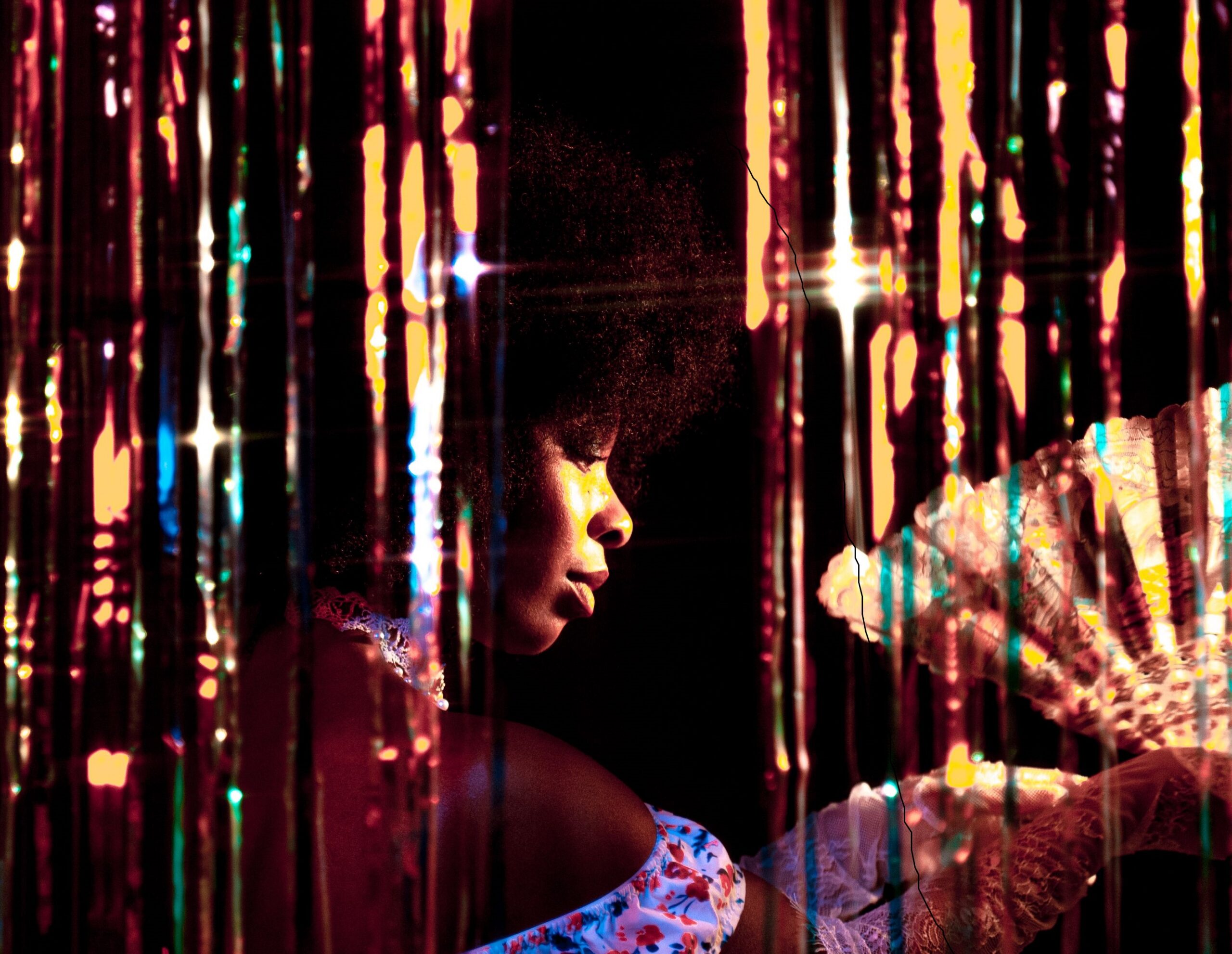 Woman in elegant attire enjoying a night out amidst shimmering lights.